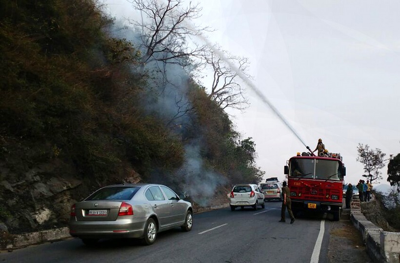 Dharampur : Firefighters douse a forest fire in Dharampur of Himachal Pradesh on May 2, 2016. (Photo: IANS)